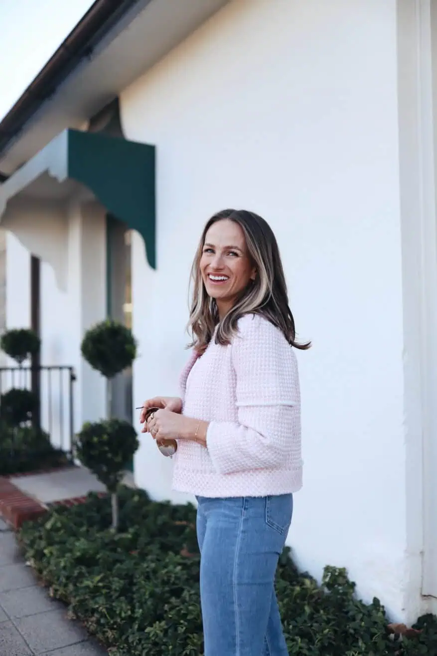 Woman wearing a pink blazer and denim jeans