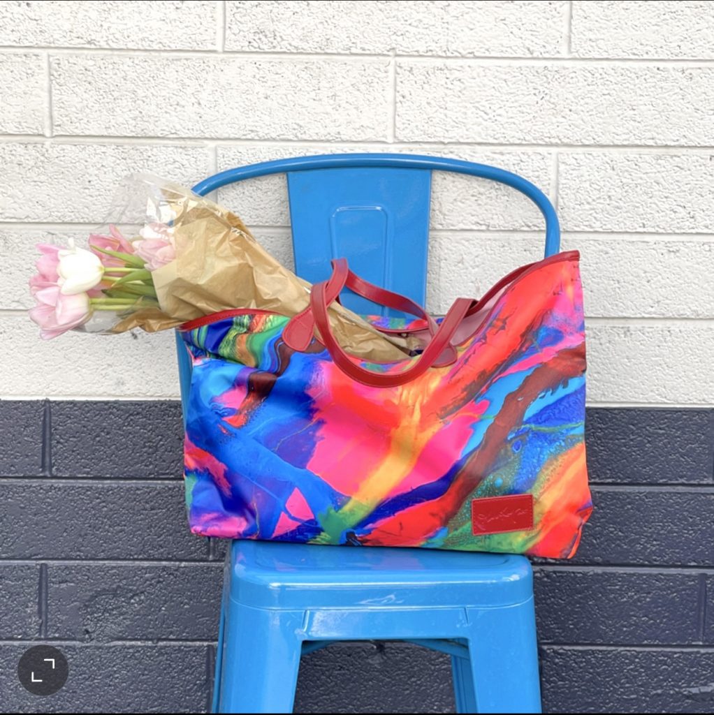 A man in blue shirt and hat standing next to table.