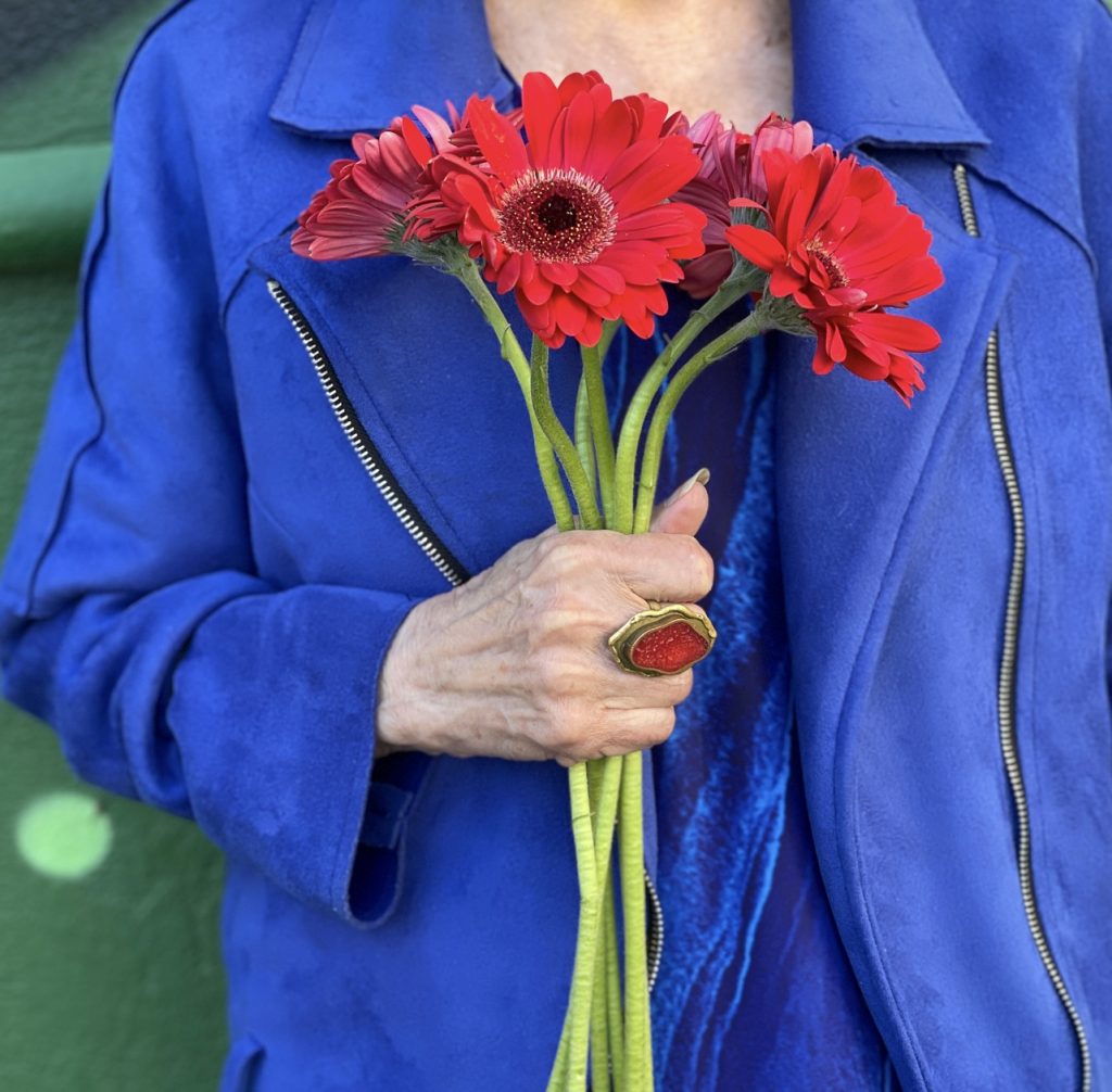A man in blue shirt and hat standing next to table.