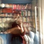 Idun St Paul with white walls, a clothing rack, perfumes, and plants in front of a large window