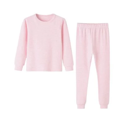 A two-piece light pink long-sleeve pajama set with a crew neck top and elastic waist pants, laid flat on a white background—perfect as cozy Easter basket fillers for kids.