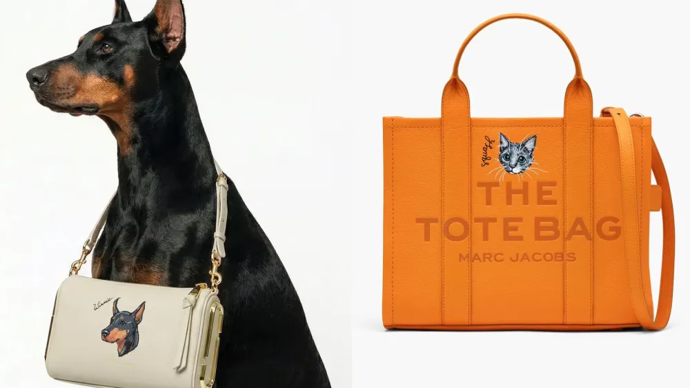 dobermann posing with a marc jacobs handbag around its neck, which bears an illustration of the dog itself; orange marc jacobs the tote bag with custom cat portrait on it