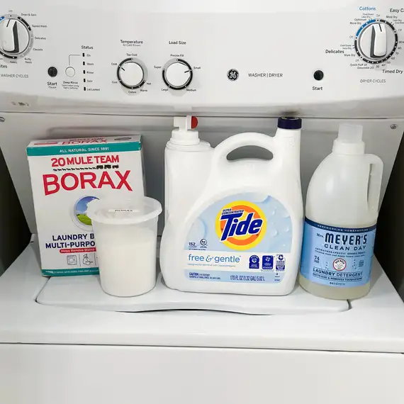 A box of 20 Mule Team drills, a container of Tide Free & Gentle liquid laundry detergent, and one of the Mr. Meyer's Clean Day shown on top of a washing machine.