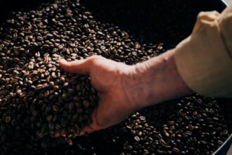 handful of coffee beans in giant vat