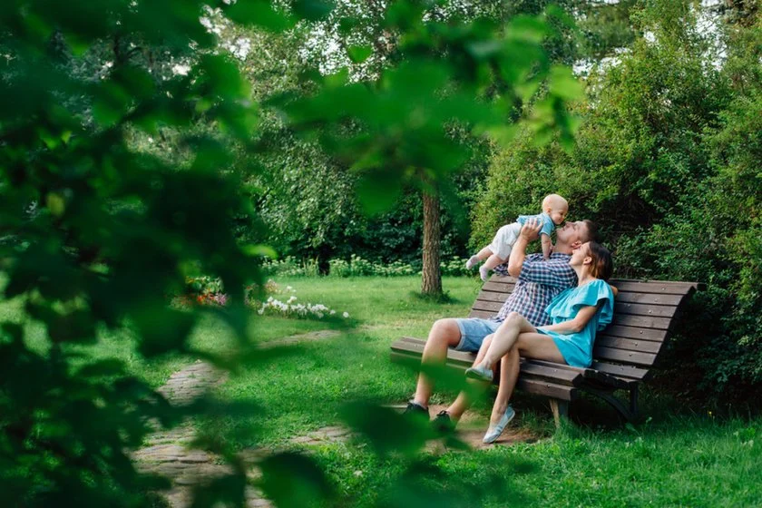 A family with a child on a park bench in spring | Skylum Blog