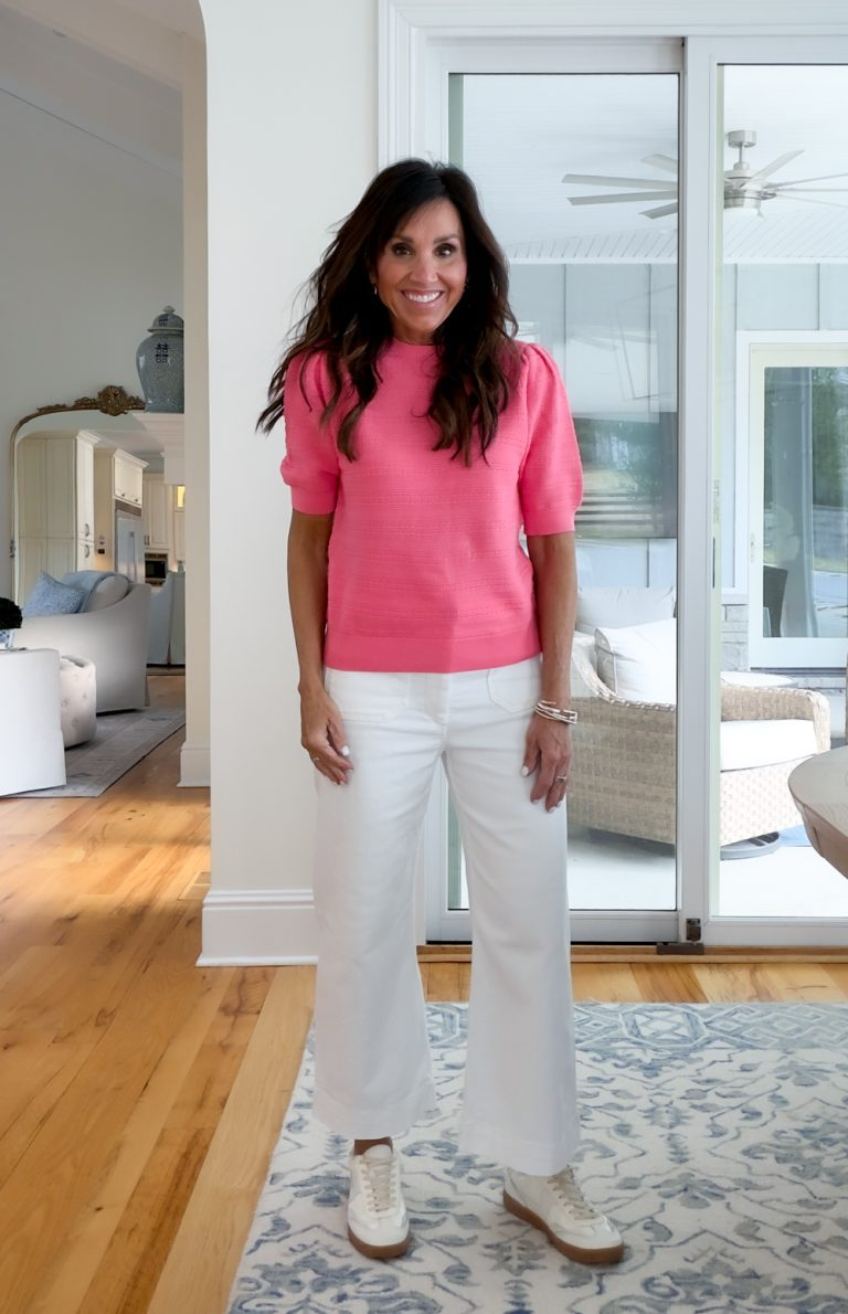 Cyndi Spivey wearing a puff sleeve sweater in pink with white pants.